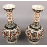 A pair of embossed vases, impressed mark to the base "BHA".