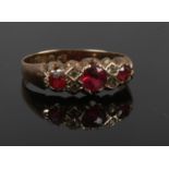 A late Victorian 9ct gold dress ring set with red stones and diamond chips. Assayed Chester 1900,