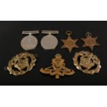 A group of four World War II medals, Royal Artillery cap badge and two British Army Warrant Officers
