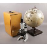 A cased Brunel microscope, along with a globe on stand.