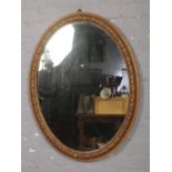 An oval gilt frame mirror.