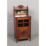 A Victorian mahogany music cabinet. With mirror back painted with water lilies, astragal glazed