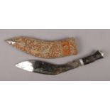 An Eastern Kukri knife in embroided and white metal mounted sheath.