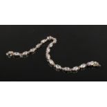 A silver and cubic zirconia line bracelet in case, 19cm.