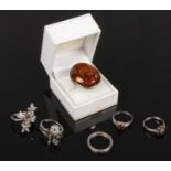 A large silver ring set with an amber tablet along with five other silver dress rings.