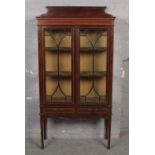 A Victorian mahogany inlaid display cabinet with two drawer base.