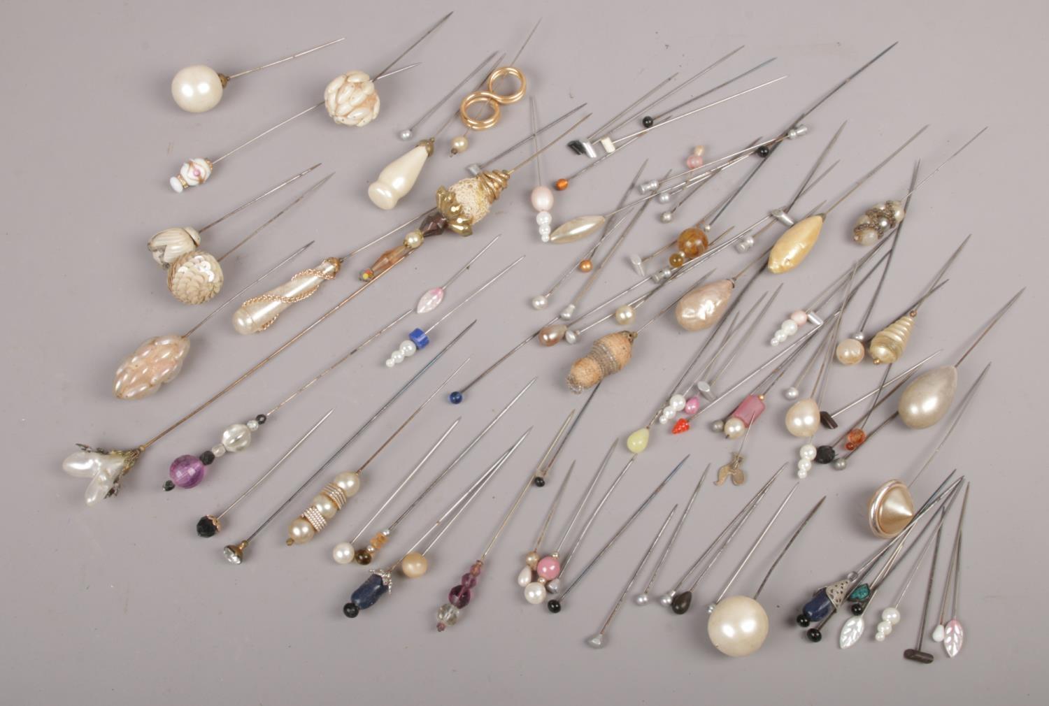 A collection of hat pins, to include sugar paste examples