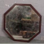A large octagonal bevel edged wall mirror in walnut frame, 101cm wide.
