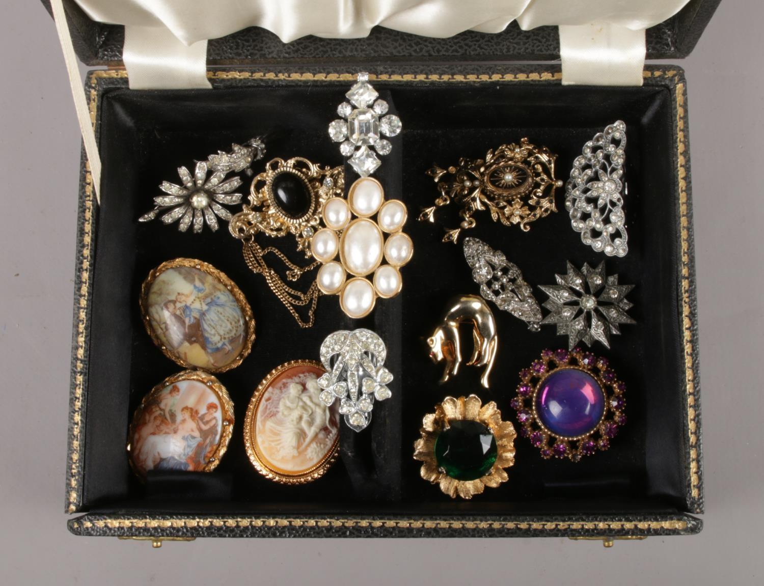 A jewellery box with contents of costume brooches, including vintage examples.