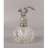 A sterling silver mounted cut glass perfume atomiser moulded with rococo scrolls, 13cm.