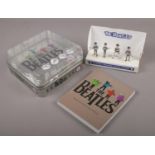 The Beatles card display with four plastic figures along with a The Beatles badge and book set.