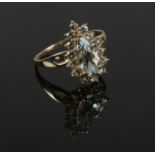 A 10ct gold cluster ring set with pale blue / green gemstones, with one large pear cut stone under a