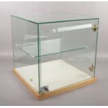 A lockable glass display case, with shelf to interior. (43.5cm x 44cm x 44cm)