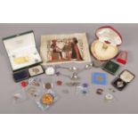 A tin of collectables to include white metal pocket watch, cased string of pearls, silver spoons,