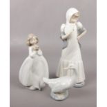 Three Nao figures; two of girls and one of a goose. Damage to flower on small girl figure.