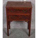 A mahogany two drawer chest on slender leg support.