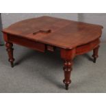 A large Victorian mahogany wind out extending table, raised on turned supports with winding