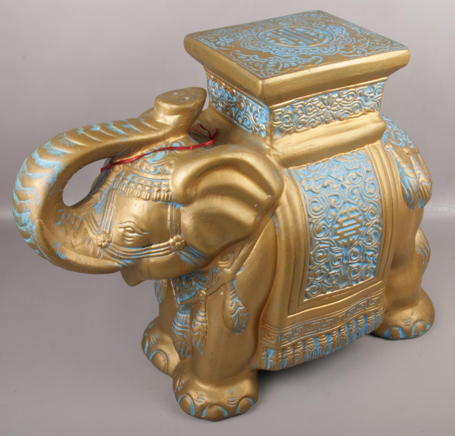 A decorative gilt pottery stand formed as an Indian elephant.