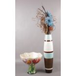 A Blue Sky vase decorated with tube lined flowers, along with a tall vase with floral display.