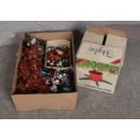 A box of Christmas decorations to include tinsel baubles, Christmas tree stand, etc.