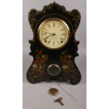 A carved and painted J.C. Brown wall/ large mantel clock, chiming on a coil gong.