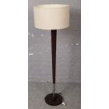 A modern chrome and hardwood tapering standard lamp.