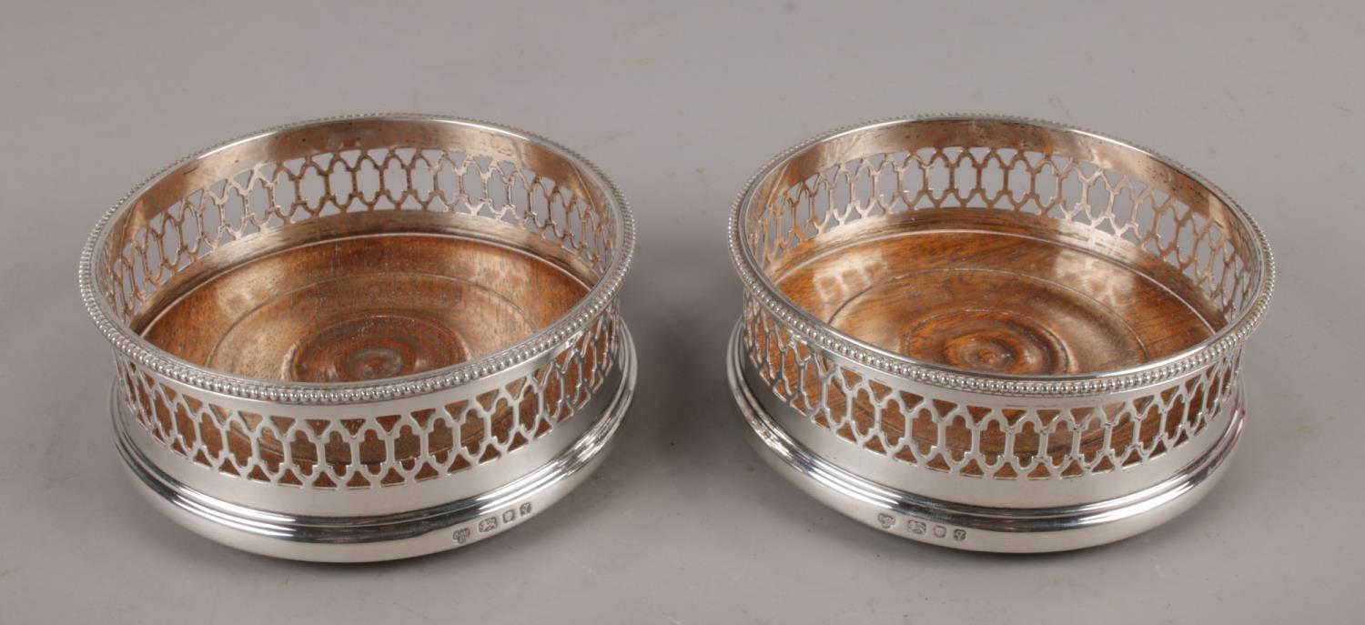 A pair of silver and oak wine coasters, assayed London 1971 by C.J Vander Limited. (11cm diameter).