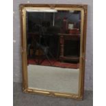 An ornate gilt framed wall mirror with bevelled glass, 71cm x 103cm