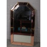 A large bevel edged wall mirror with peach glass and gilt metal boarder. (115cm x 65cm)