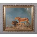 A gilt frame oil on canvas, landscape scene with a lion and lioness, signed indistinct. (50cm x