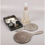 A silver dressing table mirror, a white metal example and a silver babies rattle head, Along with