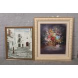 Two framed oils on canvas; one a landscape street scene, the other a floral still life, both signed.