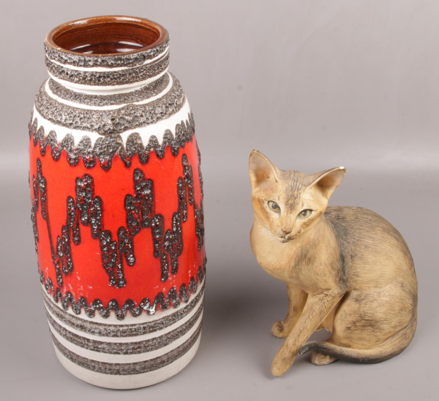 A large west Germany pottery vase along with a ornamental cat signed J E Haiselden to the base.