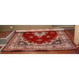 A large red ground wool carpet with central medallion design, 300cm x 400cm.