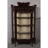 A large ornate carved mahogany display cabinet raised on cabriole legs. (180cm x 108cm)