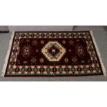 A red ground wool rug, with geometric design. (217cm x 131cm).