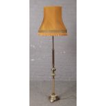 A reeded brass and onyx standard lamp with mustard shade.