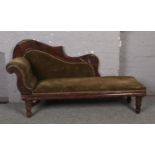 A carved Victorian chaise lounge.