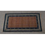 A small woolen rug in blue with key fret border, 78cm x 145cm.