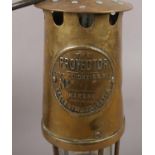 The Protector Lamp & Lighting Co Miners lamp, to include two other similar examples