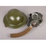 A military Brodie type helmet, along with a WWII gas mask stamped Avon 1-41 and baring the broad
