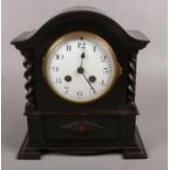 An oak 8 day dome top mantel clock with barley twist columns, chiming on a coil gong.