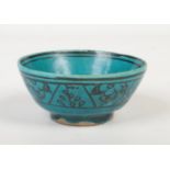 A 19th century Persian turquoise glazed earthenware bowl. With black enamel bands of stylized