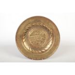 A 17th century brass alms dish. Embossed with a rosette centre under a gadrooned well and with a