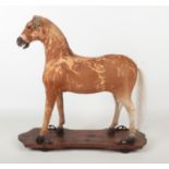 A child's 19th century toy pull along horse. With pony hide, raised on a pine plinth with metal