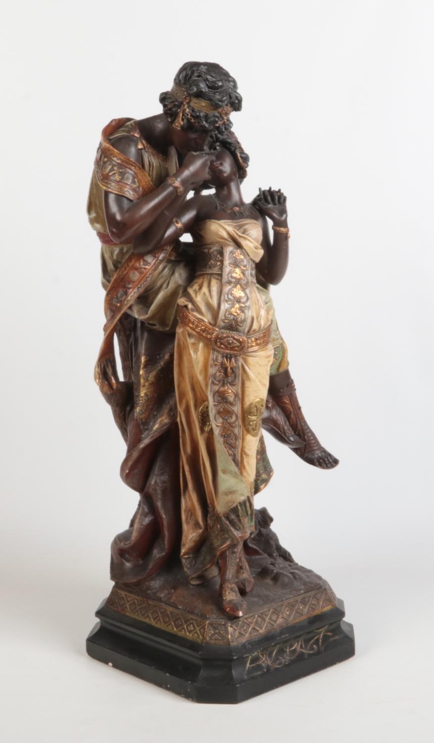 A large Art Nouveau painted terracotta figure group. Odalisque and companion. Raised on a canted