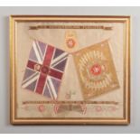 A framed embroidered silk crest, Northumberland Fusiliers over crossed colours. Inscribed, presented