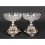 A pair of silver plated and cut glass centrepieces. Each raised on a pedestal base supported on