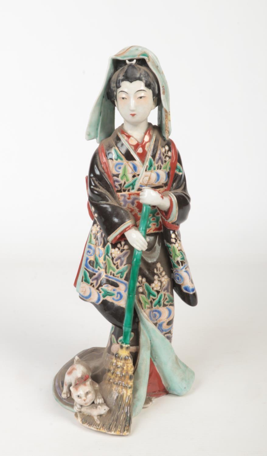 A Japanese Meiji period Kutani figure. Decorated in coloured glazes and formed as a maiden with a