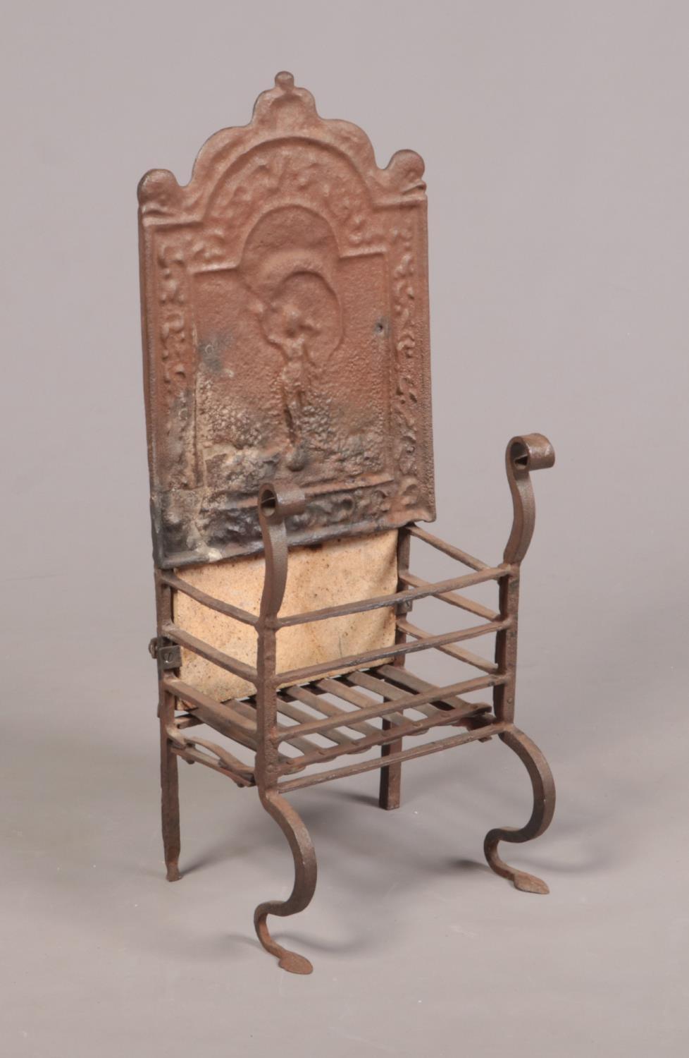 An 18th century wrought iron fire grate. The arch top back decorated in relief with a figure and